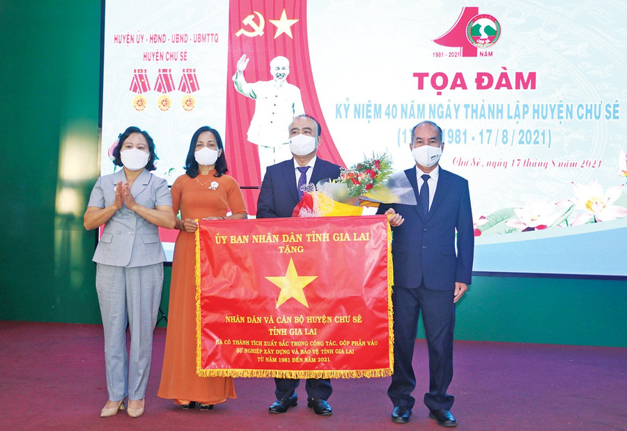 Thừa ủy nhiệm của Chủ tịch UBND tỉnh, Phó Chủ tịch HĐND tỉnh Ayun H’Bút (bìa trái) trao cờ Vì sự nghiệp xây dựng và bảo vệ tỉnh Gia Lai cho Nhân dân và cán bộ huyện Chư Sê nhân kỷ niệm 40 năm Ngày thành lập (17/8/1981-17/8/2021). Ảnh: Q.T 1qt1.jpg
