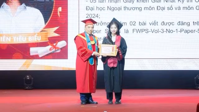 Lê Thị Thanh Nhàn nhận khen thưởng dành cho sinh viên tiêu biểu của hiệu trưởng Trường đại học Ngoại thương trong lễ tốt nghiệp sớm của K60. ẢNH: THÙY DƯƠNG