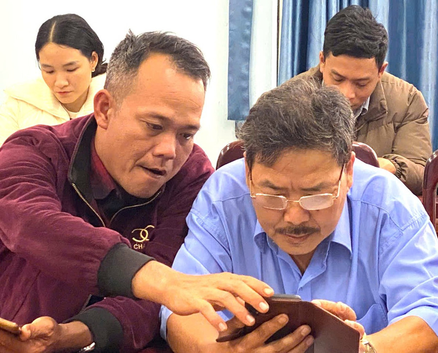 Đảng viên lớn tuổi ở xã Tuy Phước Bắc sử dụng ứng dụng Sổ tay đảng viên điện tử. Ảnh: Minh Lý