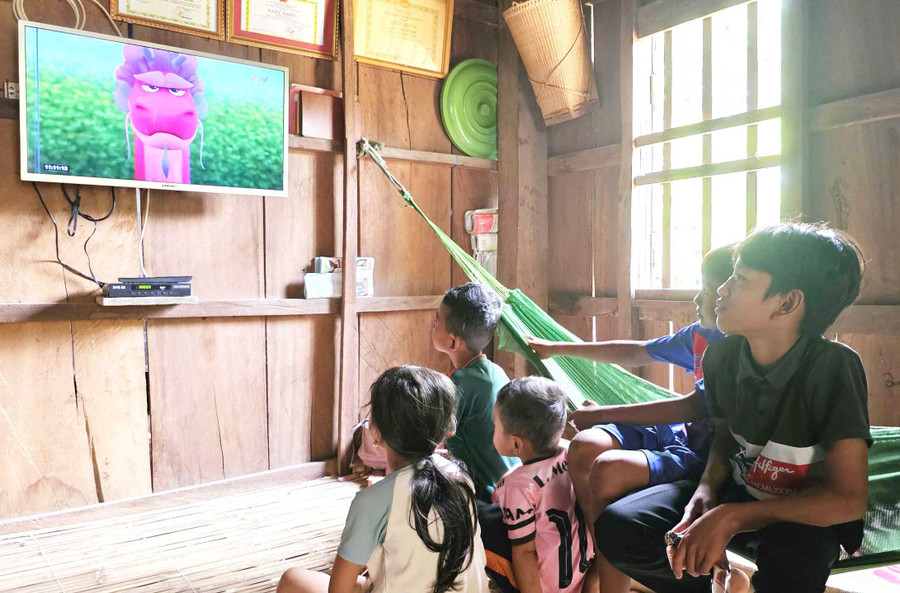 Trẻ em làng Canh Tiến xem phim hoạt hình trên tivi. Ảnh: N.H