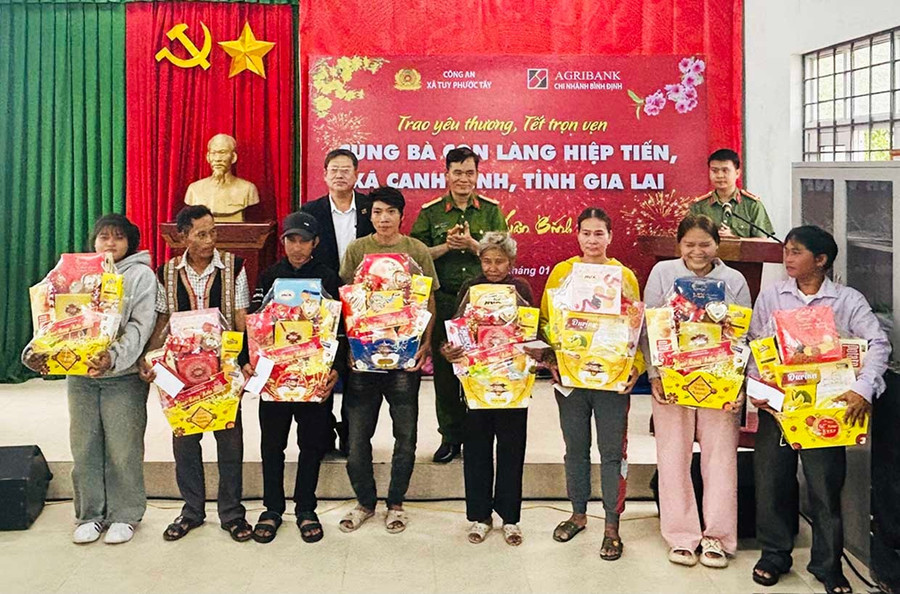 Cán bộ Công an xã Tuy Phước Tây trao quà Tết cho người dân làng Hiệp Tiến, xã Canh Vinh. Ảnh: K.A