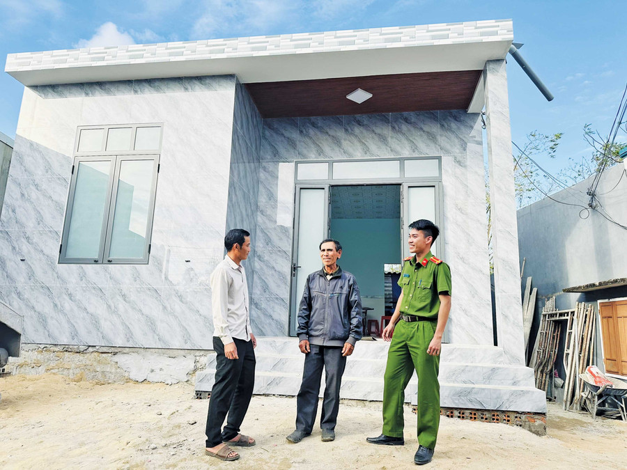 Ông Đoàn Văn Sơn (đứng giữa, thôn Tân Tiến, xã Cát Tiến) phấn khởi bên căn nhà mới. Ảnh: H.T