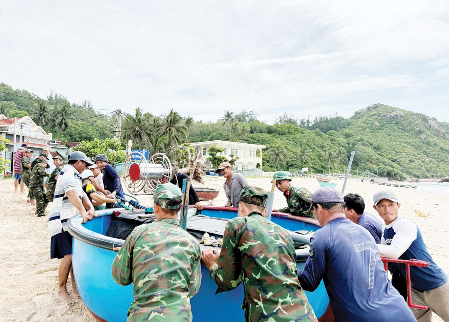 Lính đảo giúp bà con ngư dân đưa thuyền thúng vào bờ trú tránh gió bão. Ảnh: Đại đội Hỗn hợp đảo Cù Lao Xanh