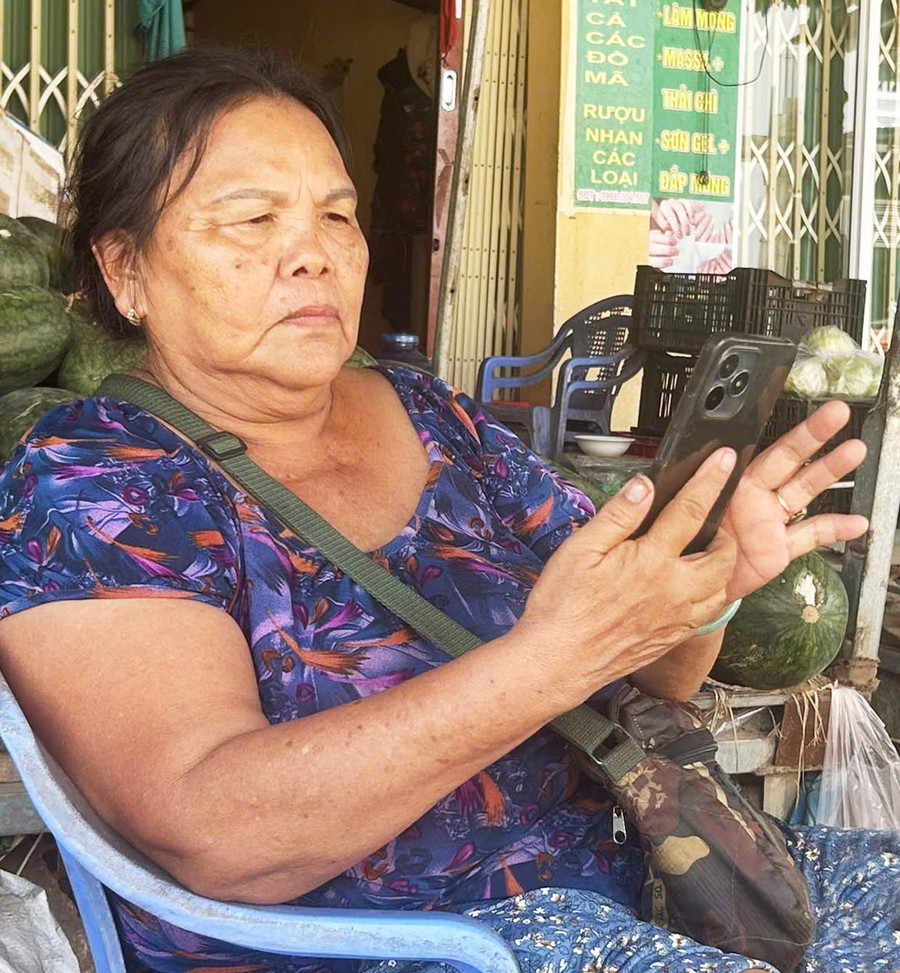 Bà Nguyễn Thị Hồng kiểm tra nhật ký chuyển khoản để quản lý thu chi trong ngày. Ảnh: Đ.T laythem.jpg