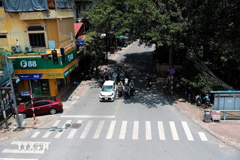 Nhiều phương tiện tham gia giao thông đỗ vào nơi có bóng mát trên đường Nguyễn Ngọc Vũ để dừng đèn đỏ. Ảnh: Lê Đông/TTXVN thoi-tiet-ngay.jpg