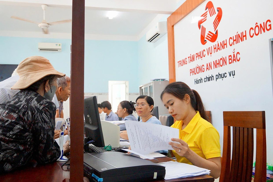 Chị Nguyễn Thị Thanh Hương (bìa phải) hỗ trợ người dân thực hiện nộp hồ sơ thủ tục hành chính tại Trung tâm Phục vụ hành chính công phường An Nhơn Bắc. Ảnh: N.M 11-anh.jpg