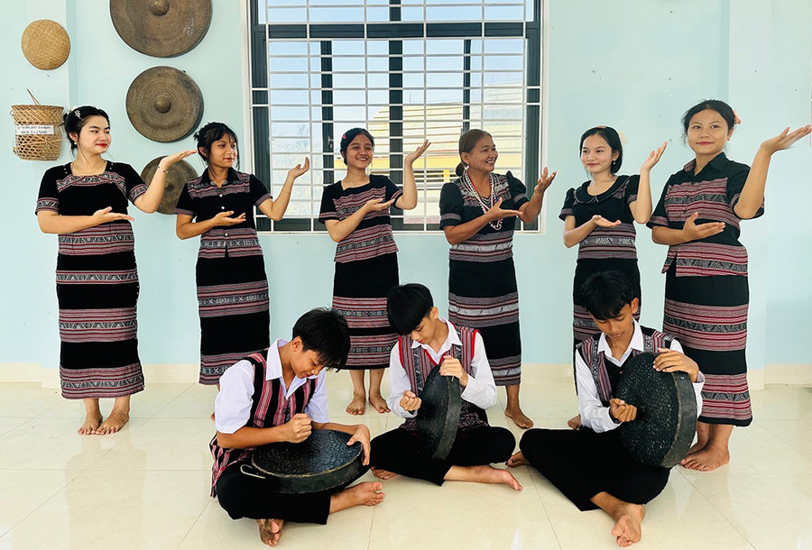 Các thanh thiếu niên được bà Tuyết (hàng sau, thứ 3 từ phải sang) thực hành một bài đánh chiêng, hướng dẫn cùng hát và múa. Ảnh: D.Đ Thực hành một bài đánh chiêng, hướng dẫn cùng hát và múa.