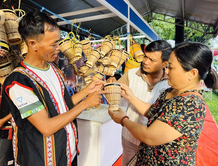 Anh Rinh (bìa trái, làng Ngơm Thung, xã Ia Băng) giới thiệu đến khách hàng sản phẩm gùi truyền thống với nhiều kích cỡ. Ảnh: M.N