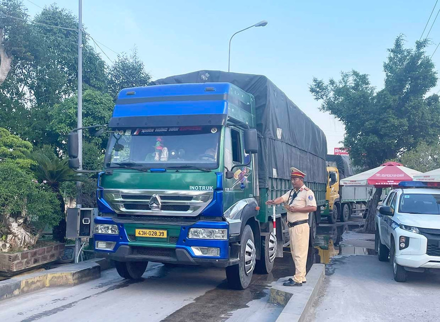 Cán bộ Trạm Cảnh sát giao thông Tuy Phước hướng dẫn tài xế điều khiển phương tiện vào cân tải trọng. Ảnh: K.A Cán bộ Trạm Cảnh sát giao thông Tuy Phước hướng dẫn tài xế điều khiển phương tiện vào cân tải trọng. Ảnh: K.A