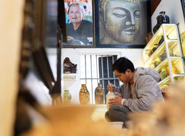 Nghệ nhân Nguyễn Viết Lâm tỉ mỉ “trang điểm” cho sản phẩm gốm. Ảnh: Mạnh Cường