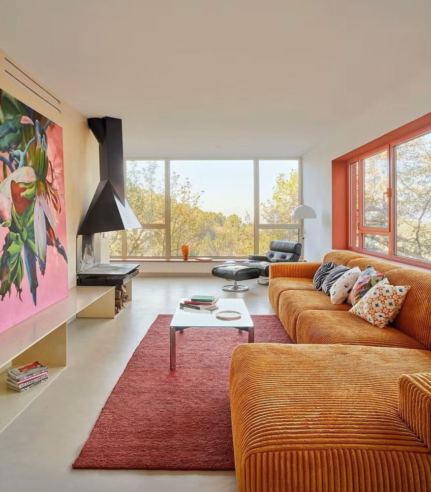 Từ đó, không gian mở rộng tới khu bếp, ban công, phòng ăn như tràn ra núi rừng, chỉ ngăn cách bằng bốn khung cửa trượt kính lớn.