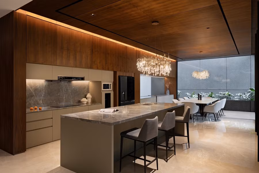 Khu vực bếp, ăn uống kết nối liền mạch với phòng khách. Bàn ăn lớn đặt gần cửa kính mở ra sân hiên và có thể nhìn ra sân trong.