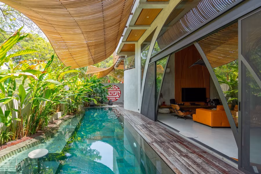 Để duy trì nhiệt độ, các tấm chắn bên ngoài được mở rộng thành hiên dài 3,5m ở tầng trệt, tạo ra một không gian râm mát giống như khi ngồi dưới bóng cây. Thiết kế này cũng giúp bảo vệ cây cối xung quanh khỏi ánh nắng gay gắt, đồng thời tạo nên sự chuyển tiếp mềm mại, liền mạch - phản ánh triết lý "Lumintu".