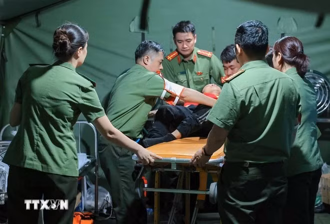 Các bác sỹ của Công an Hà Nội khẩn trương sơ cứu cho người dân bị ngã, có hiện tượng co giật khi đi xem lễ diễu binh, diễu hành tại trạm y tế dã chiến phố Liễu Giai. (Ảnh: Hoàng Hiếu/TTXVN)