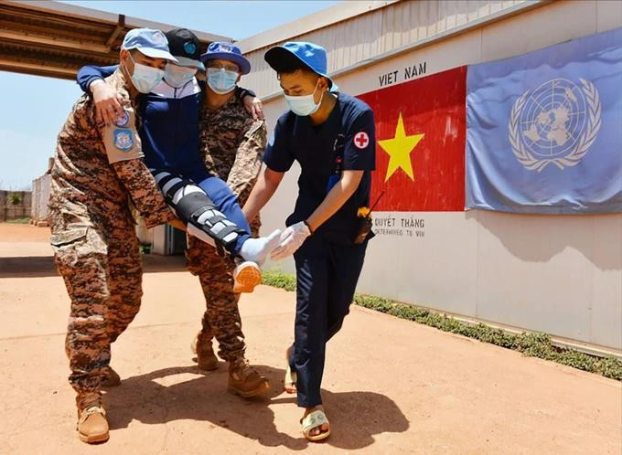 Các chiến sĩ “mũ nồi xanh” Việt Nam hỗ trợ cứu chữa người bệnh. Ảnh: BVCC mu-noi-xanhdd.jpg