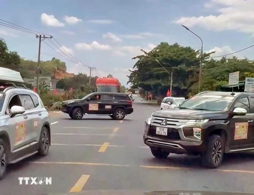 2 chiếc xe ngang nhiên đậu so le trên cả 2 chiều, chặn đường để đoàn xe doanh nhân băng qua Quốc lộ 20. Ảnh: TTXVN phát lamdong.jpg