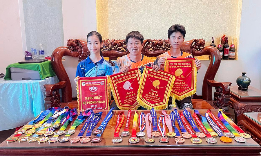 Anh Lê Văn Trường (ở giữa) cùng 2 con Lê Tiến Dũng và Lê Thị Minh Thư. Ảnh: H.H 0bgle-tien-dung-bia-phai-va-le-thi-minh-thu-bai-traihai-truyen-nhan-nho-tuoi-cua-anh-le-van-truong-anh-hh.jpg