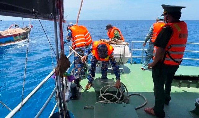 Bộ đội Biên phòng Quảng Ngãi đưa thi thể em Kh. vào bờ. Ảnh: V.T Bộ đội Biên phòng Quảng Ngãi đưa thi thể em Kh. vào bờ. Ảnh: V.T