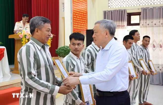 Niềm xúc động của một phạm nhân khi nhận Giấy chứng nhận đặc xá do Phó Thủ trướng Thường trực Nguyễn Hòa Bình trao. Ảnh: Tiên Minh/TTXVN