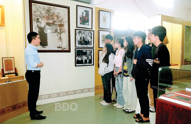 Anh Trần Ngọc Cúc, thuyết minh viên Bảo tàng tỉnh, giới thiệu về hiện vật chiếc áo khoác Bác Hồ tặng cho đồng chí Huỳnh Đăng Thơ vào năm 1958. Ảnh: NGỌC NHUẬN 2bd.jpg
