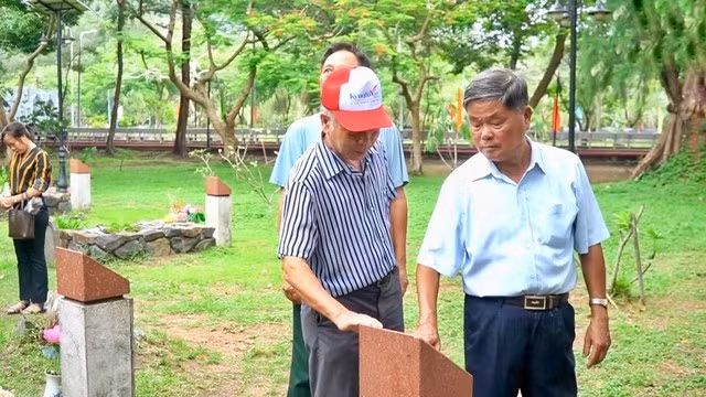 Trung tướng - Anh hùng Lực lượng vũ trang nhân dân Châu Văn Mẫn (phải) cùng đồng đội dừng lại, đặt tay trước những tấm bia mộ của đồng đội tại Nghĩa trang Hàng Dương, Côn Đảo