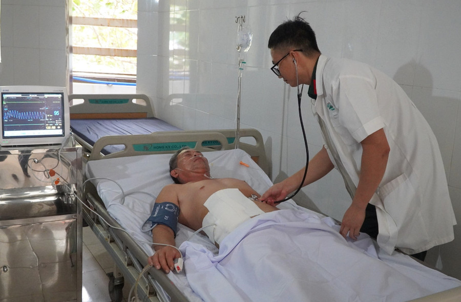 Bác sĩ Hồ Sỹ Ngọc thăm khám cho thuyền viên Nguyễn Sang. Ảnh: DN truong-sa-dd.jpg