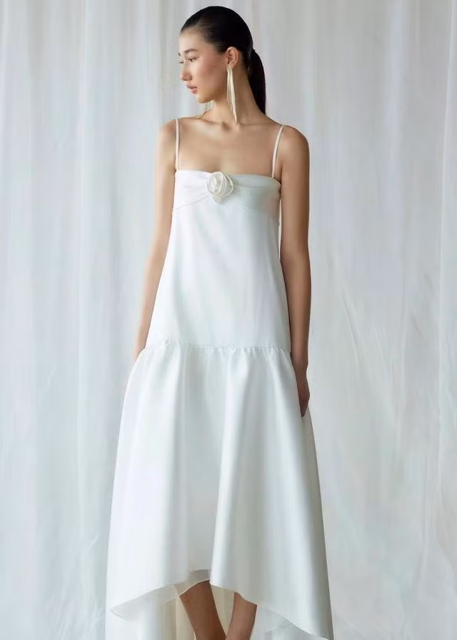Đầm suông hạ eo màu trắng ngà tôn nét đẹp trong trẻo và tươi mới của quý cô. Thiết kế giản đơn nhưng tinh tế nhờ vào chi tiết hoa đính trên ngực áo, cấu trúc layer xếp tầng và sự bất đối xứng của phần chân váy. ẢNH: NOSBYN STUDIO