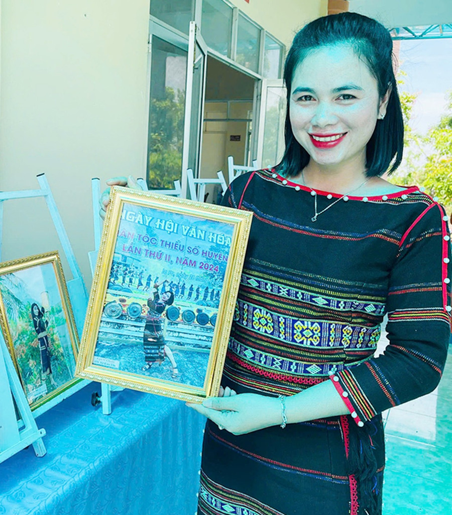 Chị Kpă H’Chuên (buôn Mơ Nang 2, xã Kim Tân) và bức ảnh đạt giải nhất cuộc thi “Nét đẹp trang phục truyền thống các dân tộc thiểu số qua ảnh”. Ảnh: V.C 1clay.jpg