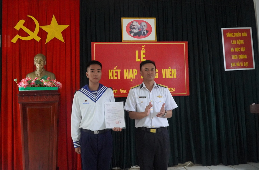 Binh nhất Nghiêm Công Phong xúc động nhận quyết định kết nạp đảng viên. Ảnh: DN truong-sadd.jpg