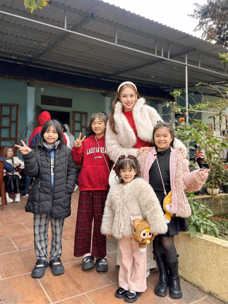 Á hậu Ngọc Hằng mặc áo dài đỏ khi đi chúc Tết họ hàng trong ngày mùng 1 Tết.