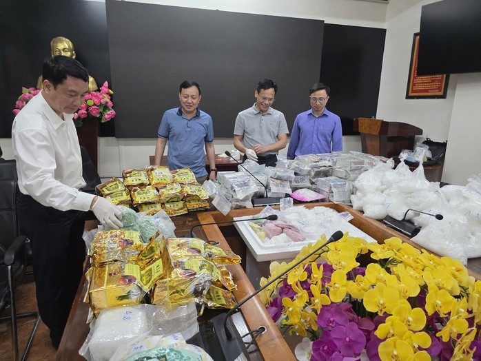 Thành viên Ban chuyên án cùng số tang vật thu giữ được. Ảnh: Bộ Công an