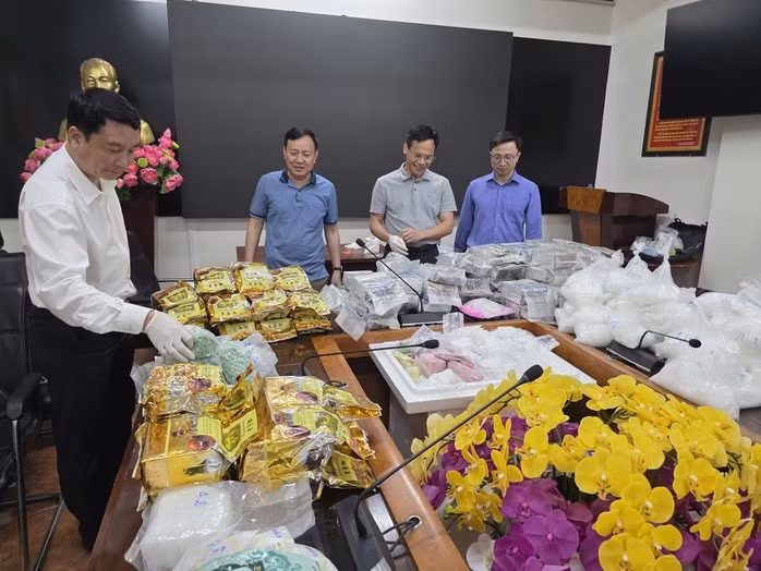 Thành viên Ban chuyên án cùng số tang vật thu giữ được. Ảnh: Bộ Công an