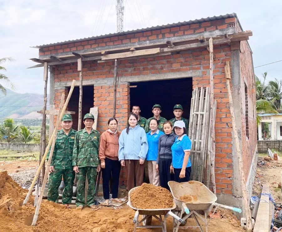 Chị Huỳnh Thị Tình (thứ 2 từ phải sang, ở tổ dân phố Kim Giao Trung, phường Hoài Nhơn Đông) được cán bộ, chiến sĩ Đồn Biên phòng Tam Quan Nam hỗ trợ xây dựng nhà tình nghĩa. Ảnh: ĐVCC