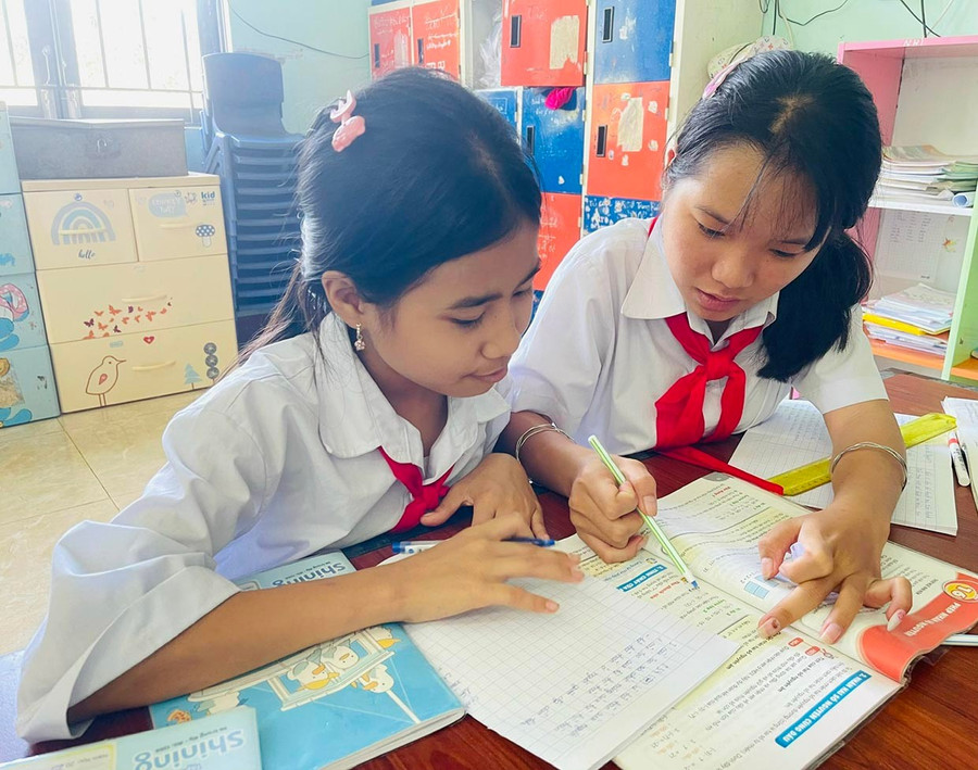 Em Đàm Thị Thảo Vy (bên phải) hướng dẫn em Vi Thị Ánh Tuyết làm bài tập. Ảnh: P.D