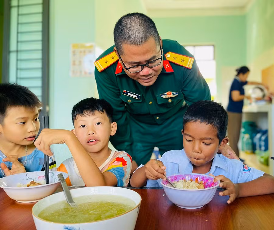 Cán bộ Đoàn Kinh tế - Quốc phòng 710 quan tâm thăm hỏi bữa ăn của các em tại điểm nội trú xã Ia Boòng. Ảnh: P.D