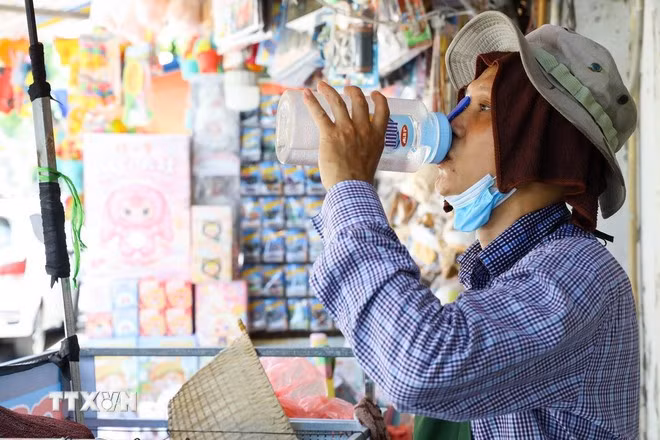 Người dân tìm cách thích nghi khi trời nắng nóng. (Ảnh: Lê Đông/TTXVN)