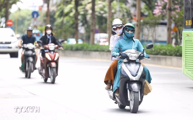 Người dân bịt kín mặt khi tham gia giao thông trong những ngày nắng nóng. (Ảnh: Lê Đông/TTXVN)