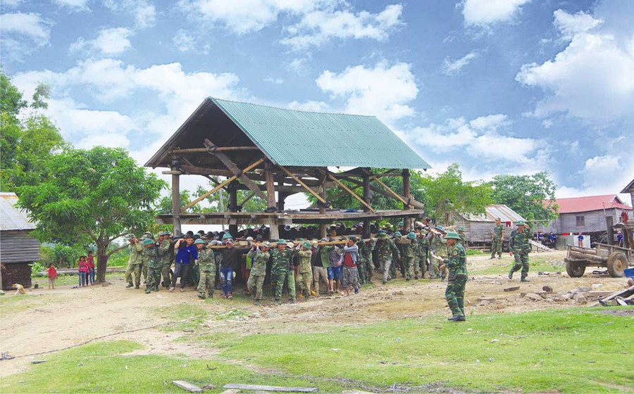 Sư đoàn 320 làm công tác dân vận, giúp người dân xã Chư A Thai chuyển nhà đến khu tái định cư. Ảnh: Vĩnh Hoàng