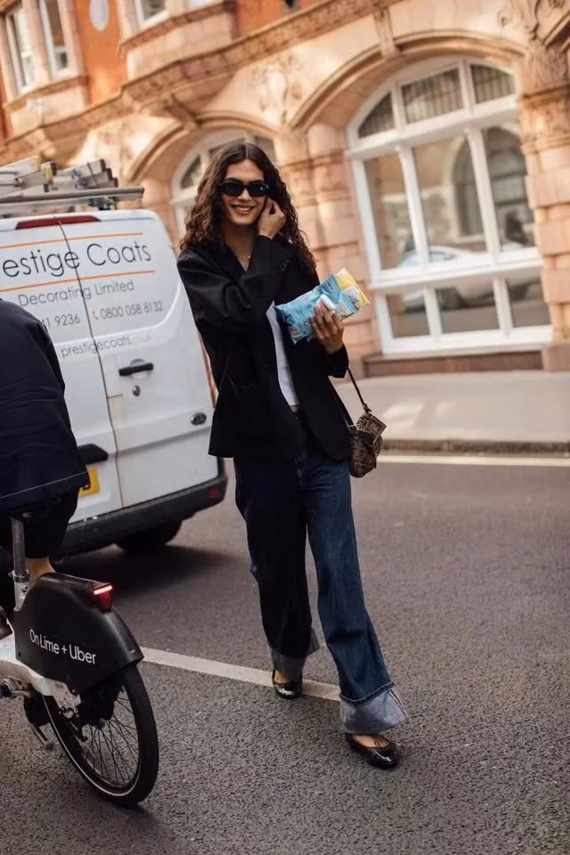 Quần jeans xắn gấu được phối cùng giày ba lê đen - một phong cách năng động, cá tính. ẢNH: @LONDONFASHIONWEEK