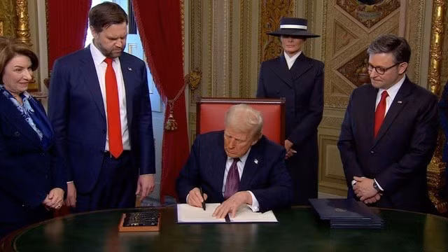 Tổng thống Trump ký một loạt văn bản ngay sau khi kết thúc lễ nhậm chức tại Đồi Capitol. Ảnh: Pool