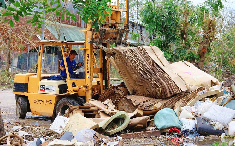 Công nhân của Công ty TNHH Đức Toàn dọn dẹp nhà xưởng, khuôn viên đơn vị khi nước lũ rút. Ảnh: Hải Yến