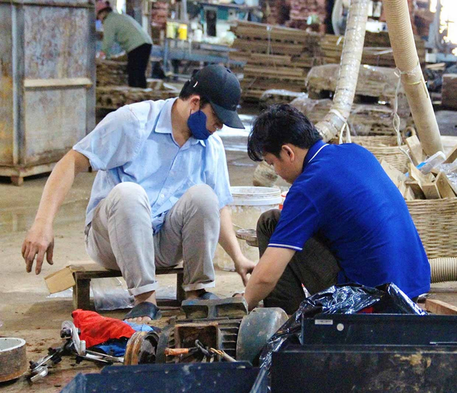 Công nhân sửa máy móc, thiết bị tại các DN bị ảnh hưởng do nước lũ. Ảnh: Hải Yến