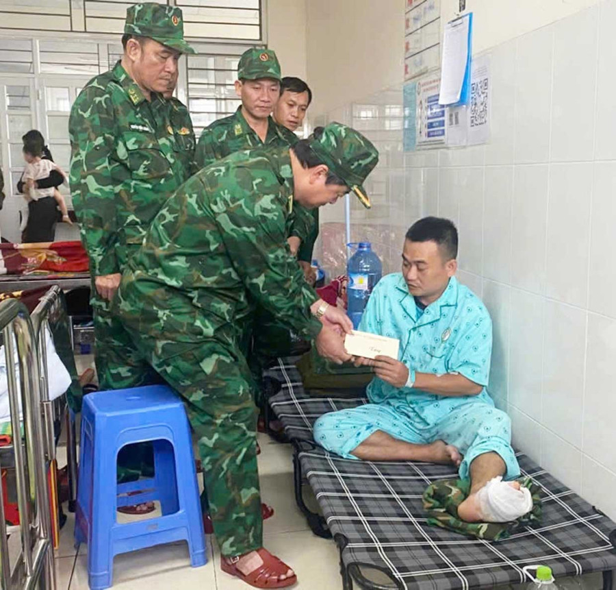 Đồng chí thăm hỏi, động viên và trao quà cho đồng chí Nguyễn Khắc Thinh, bị nạn trong quá trình giúp bà con. Ảnh: Thanh Bình