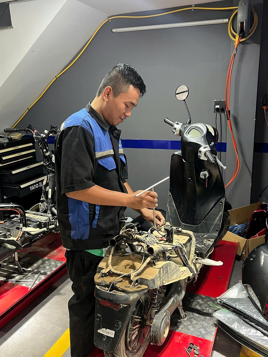 Kỹ thuật của các hãng đang sửa xe máy bị ngập lụt.