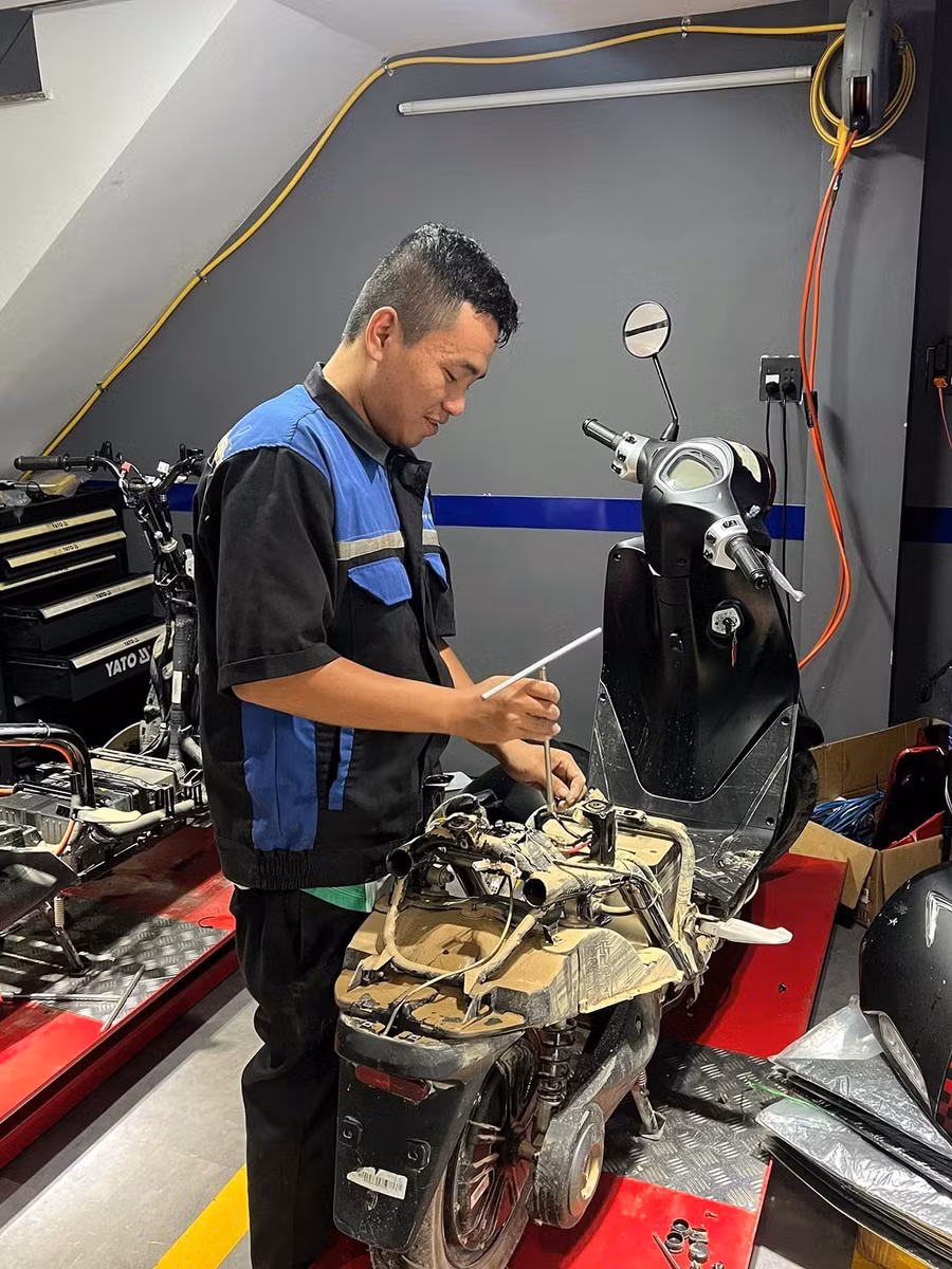 Kỹ thuật của các hãng đang sửa xe máy bị ngập lụt.