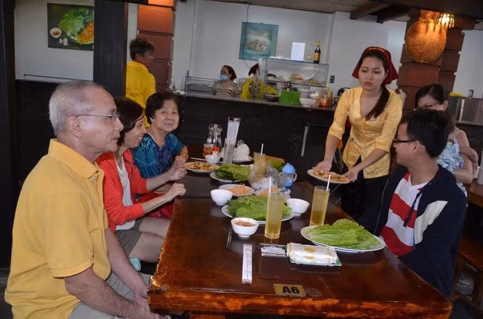 Khách du lịch thưởng thức bánh khọt tại quán Cô Ba