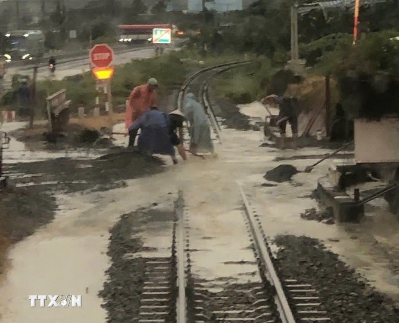 Đoạn đường sắt bị nước ngập, đất đá tràn vào đường ray, gây mất an toàn ở địa phận đường sắt chạy ngang xã Nam Cam Ranh, Khánh Hòa. (Ảnh: TTXVN phát)