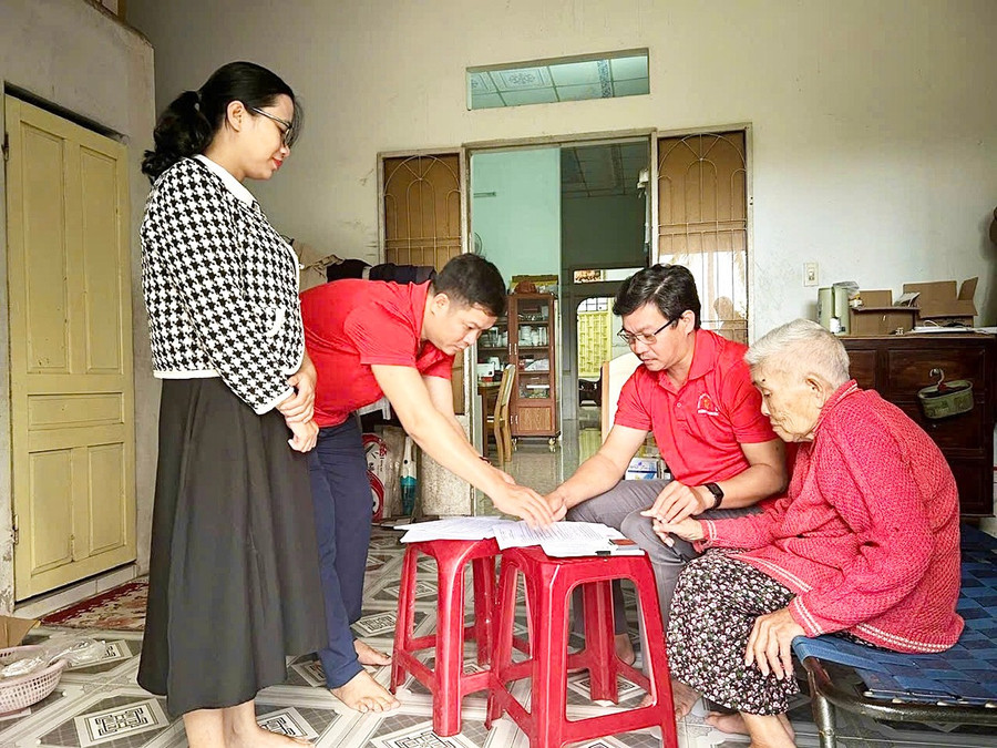 Cán bộ phường Hoài Nhơn Bắc đến nhà làm thủ tục cho cụ Lê Thị Bảy (ở khu phố Gia An Nam). Ảnh: ĐVCC