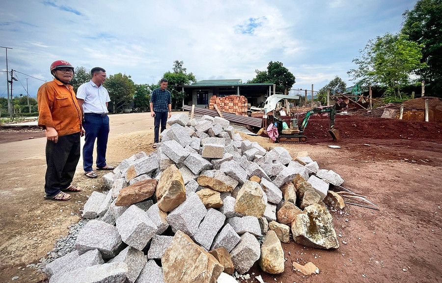Ông Lê Văn Yên (bìa trái) đang tập kết vật liệu chuẩn bị khởi công xây nhà tại khu đất tái định cư. Ảnh: M.P