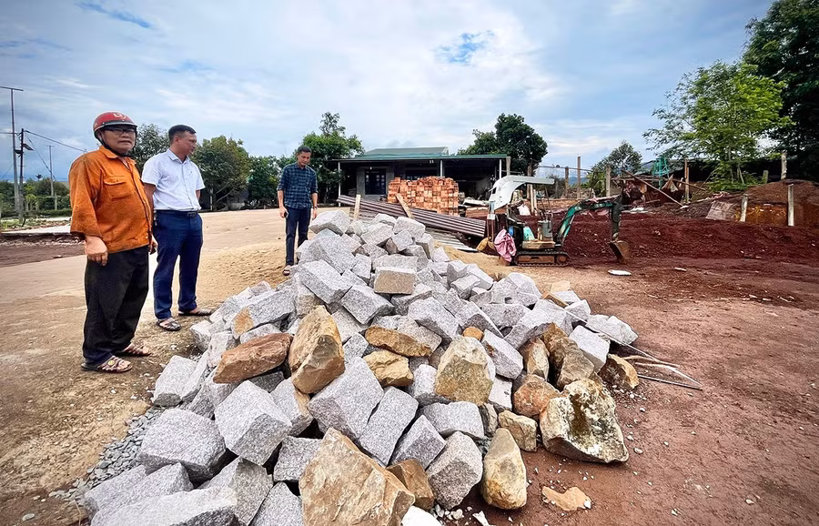 Ông Lê Văn Yên (bìa trái) đang tập kết vật liệu chuẩn bị khởi công xây nhà tại khu đất tái định cư. Ảnh: M.P